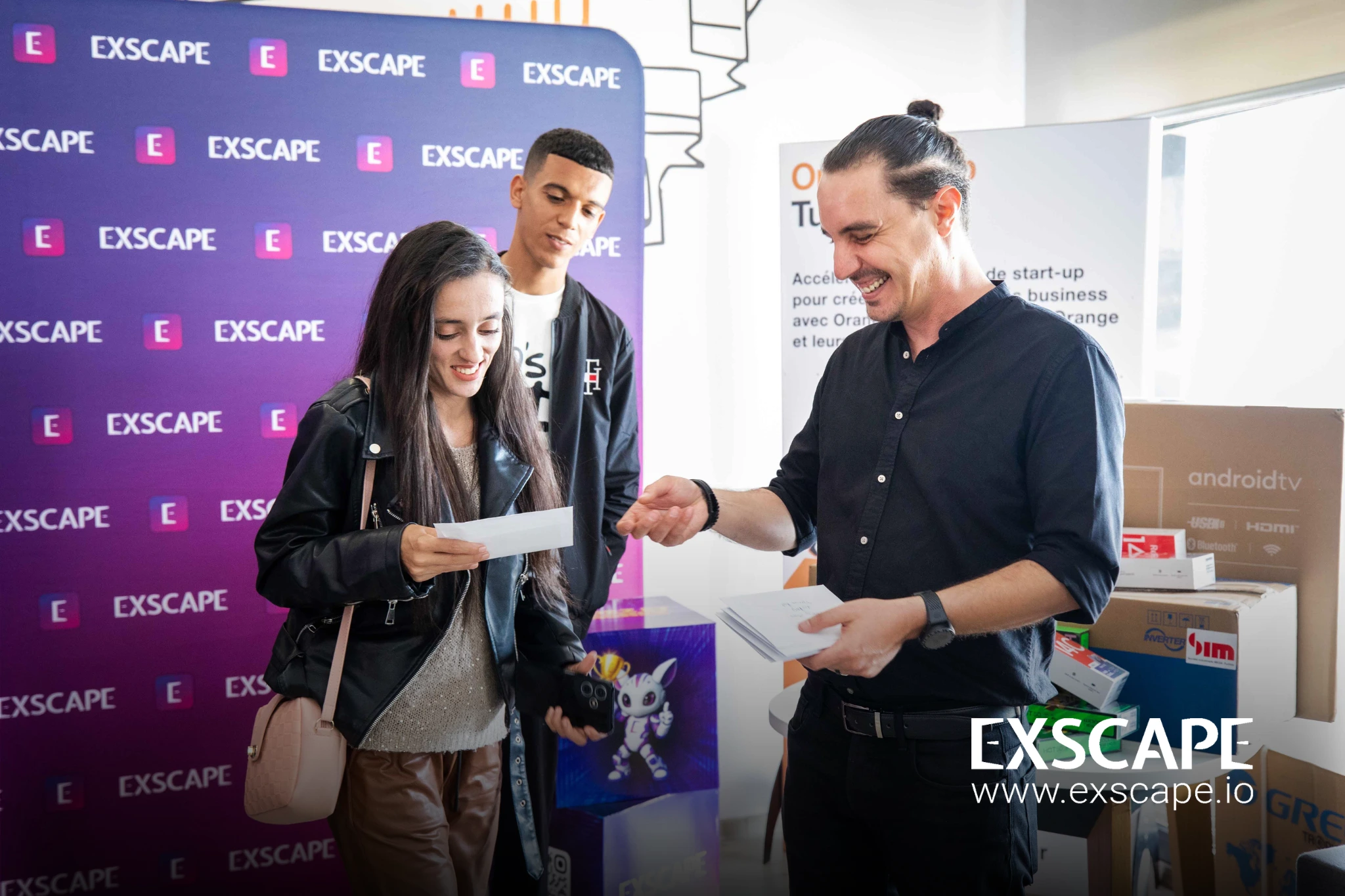 a player receives her winnings from Exscape and looks down shyly and happily art her check