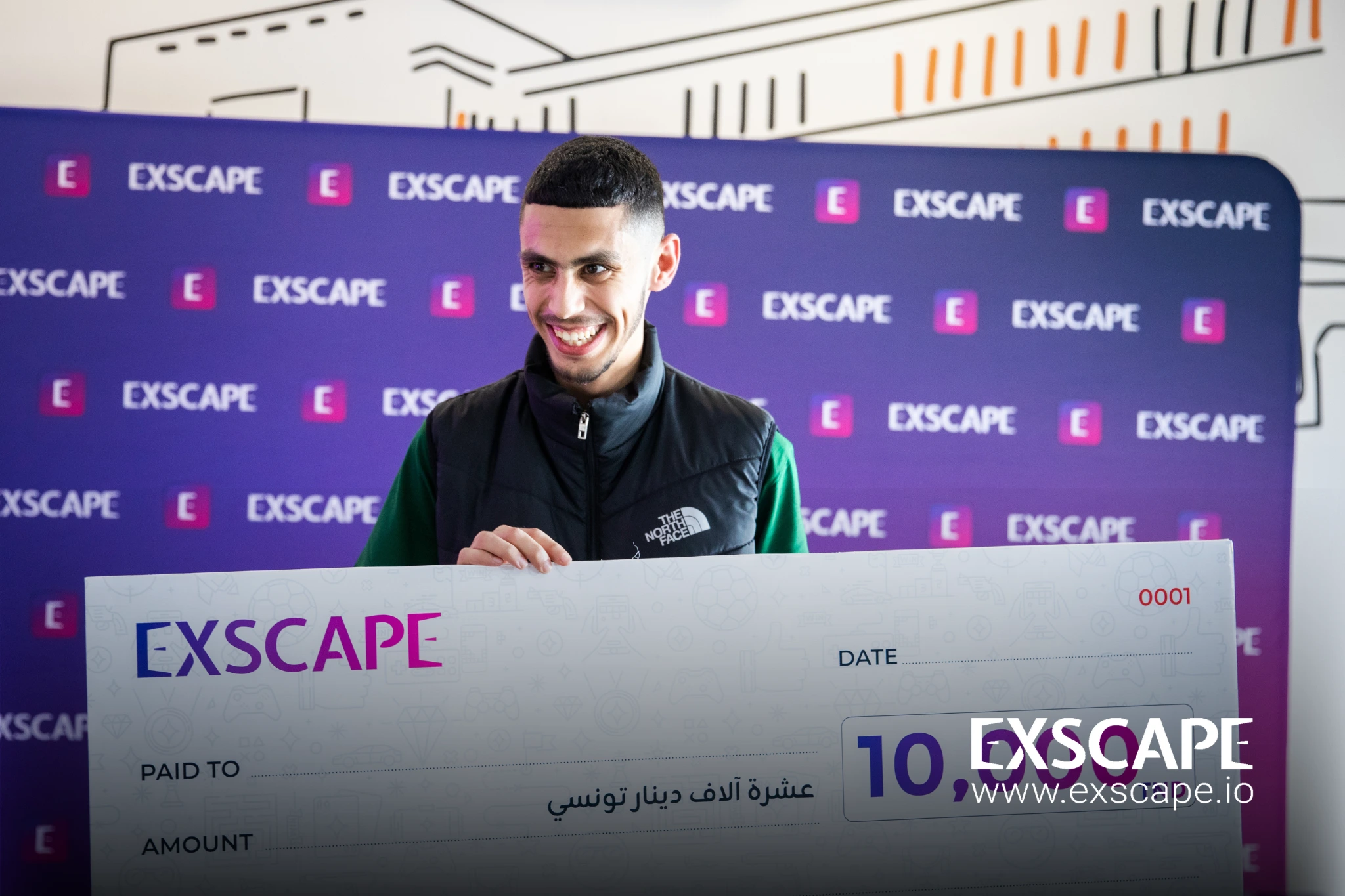 Le gagnant de la compétition Exscape Games brandit fièrement son chèque. Le gagnant de la compétition Exscape Games brandit fièrement son chèque. Le gagnant de la compétition Exscape Games brandit fièrement son chèque.